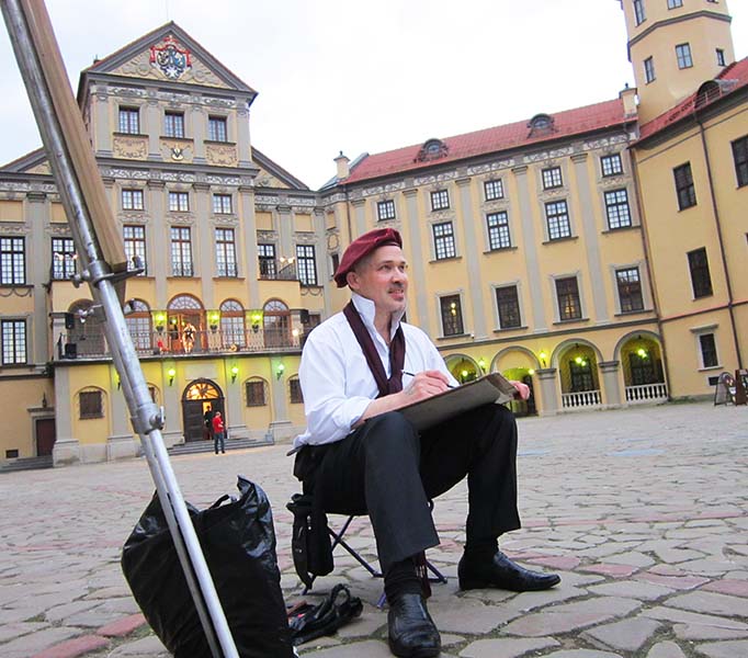 шаржист рисует на празднике в Несвиже